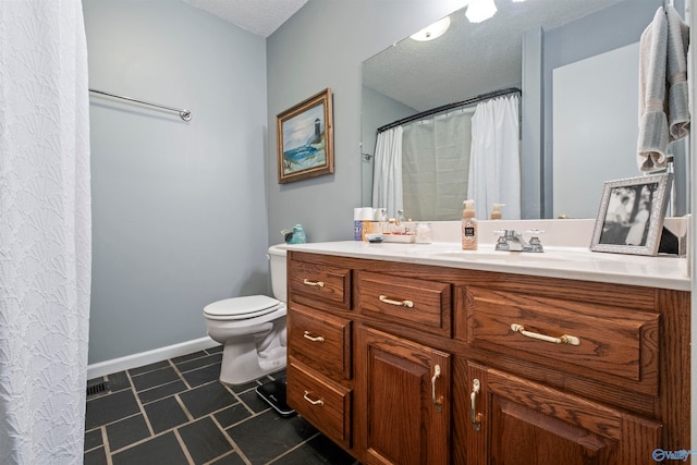 bathroom featuring toilet, vanity, and a textured ceiling