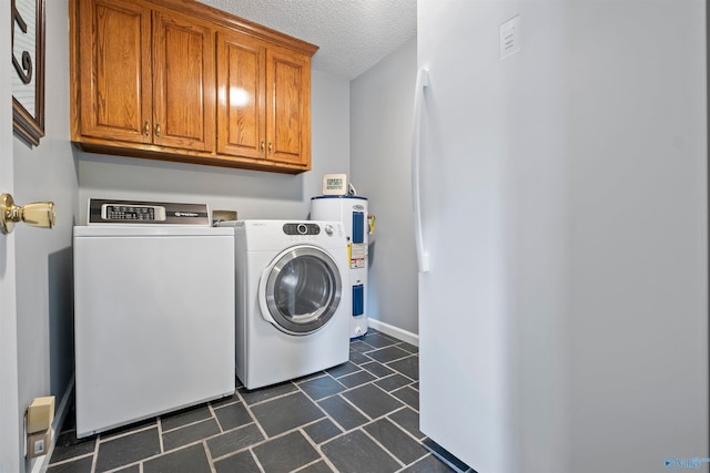 washroom featuring electric water heater, cabinets, a textured ceiling, and independent washer and dryer