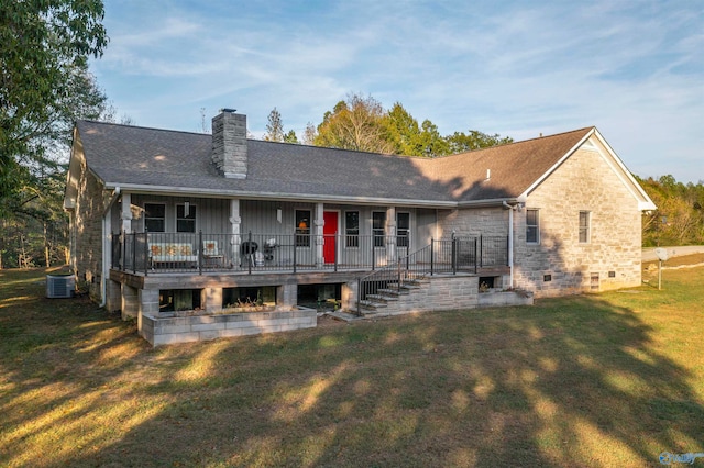 rear view of property featuring cooling unit and a yard