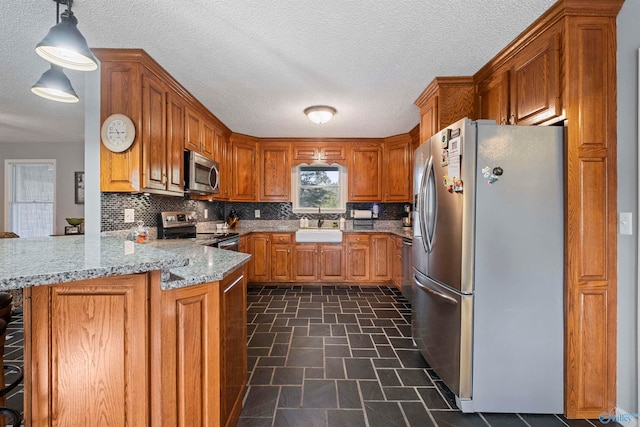 kitchen featuring stainless steel appliances, sink, a breakfast bar, kitchen peninsula, and hanging light fixtures