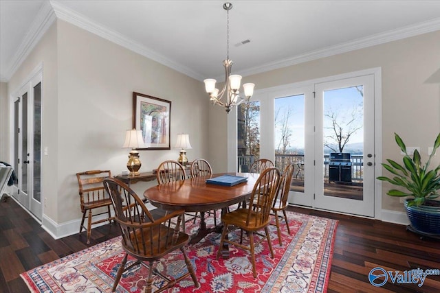 dining area with crown molding, dark hardwood / wood-style floors, and an inviting chandelier