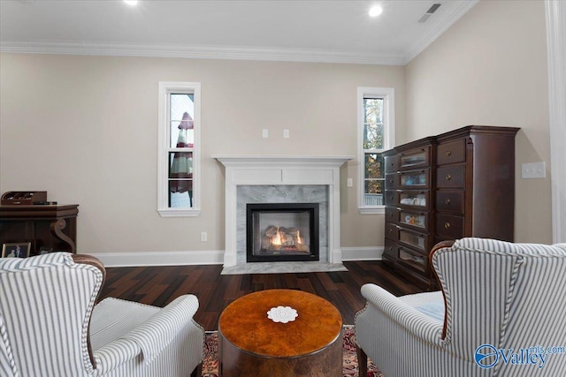 living room with dark hardwood / wood-style floors, crown molding, and a high end fireplace