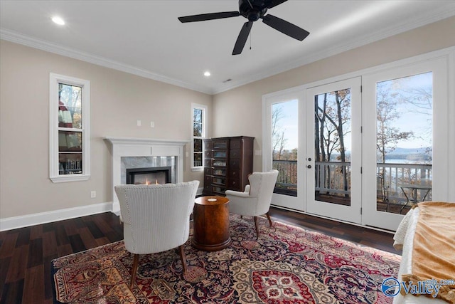 living room featuring a high end fireplace, ornamental molding, dark hardwood / wood-style floors, and a healthy amount of sunlight