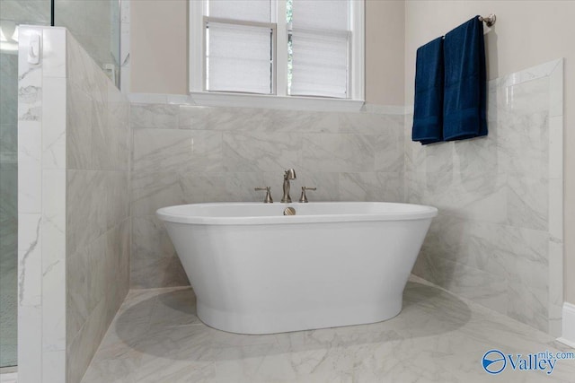 bathroom with tile walls and a tub