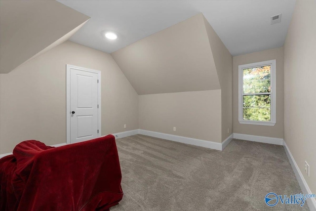 bonus room with light carpet and lofted ceiling