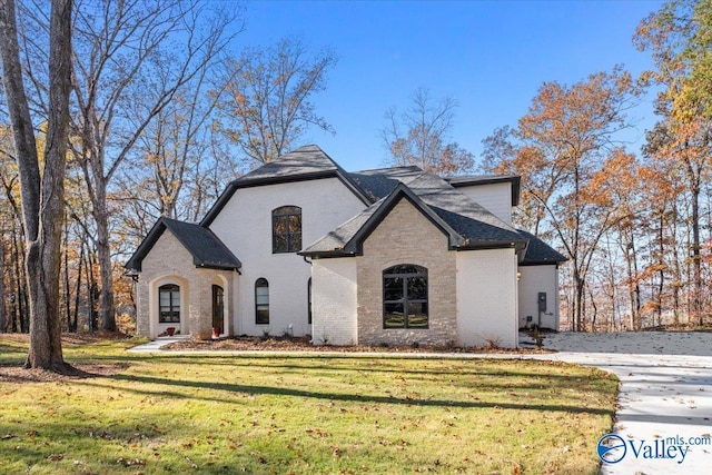 french provincial home with a front lawn