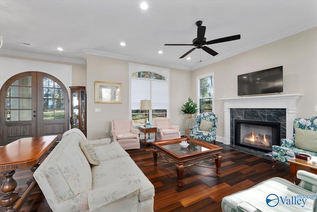 living room featuring ceiling fan, dark hardwood / wood-style flooring, ornamental molding, and a high end fireplace