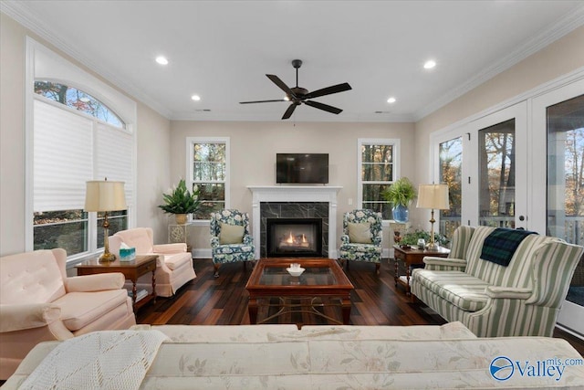 living room with ceiling fan, dark hardwood / wood-style flooring, crown molding, and a wealth of natural light