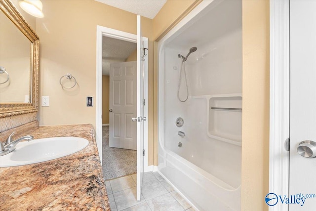 bathroom with washtub / shower combination, vanity, a textured ceiling, and tile patterned floors