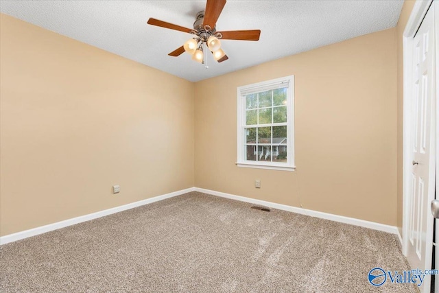 spare room with ceiling fan, a textured ceiling, and carpet flooring