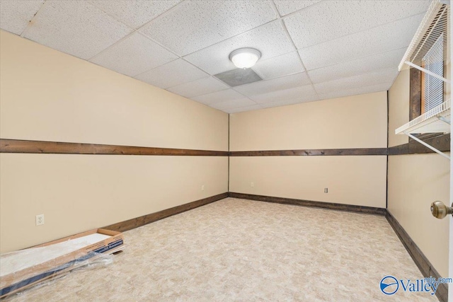 spare room with carpet flooring and a paneled ceiling