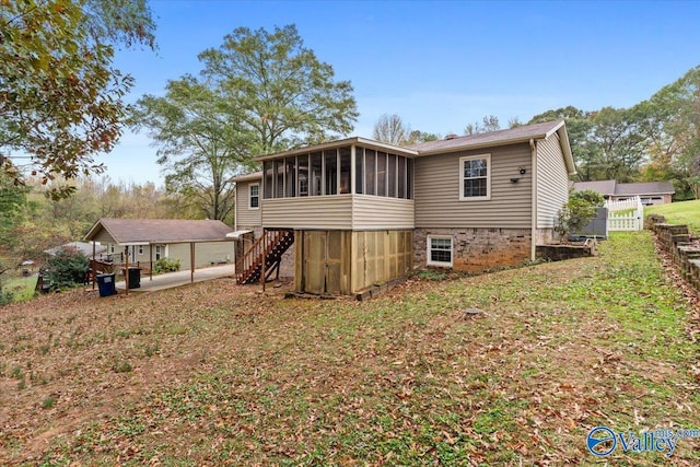 back of property with a yard and a sunroom