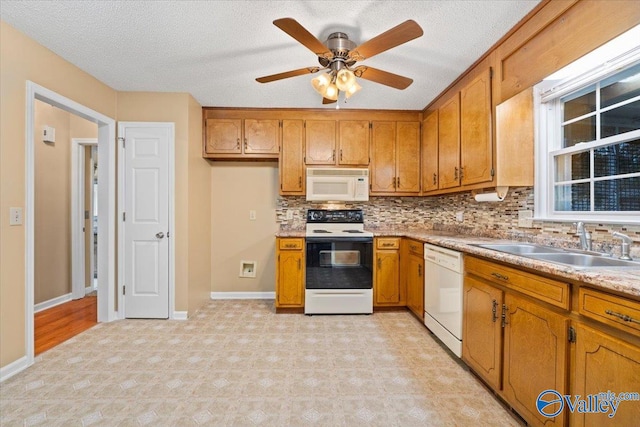 kitchen featuring sink, white appliances, tasteful backsplash, and a textured ceiling