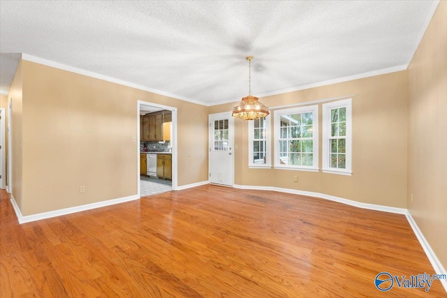 empty room featuring light wood-type flooring, a textured ceiling, a notable chandelier, and ornamental molding