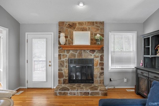 living room featuring hardwood / wood-style floors and a stone fireplace