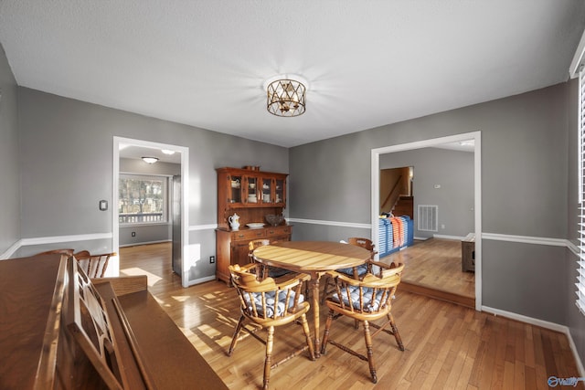 dining space featuring an inviting chandelier and light hardwood / wood-style flooring