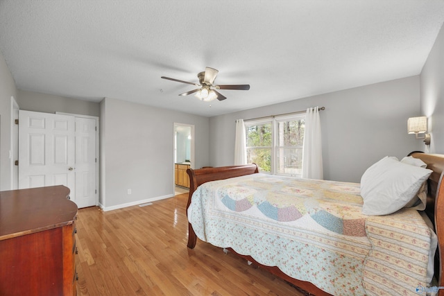 bedroom with ceiling fan, connected bathroom, a textured ceiling, and light wood-type flooring