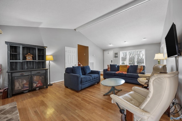 living room with vaulted ceiling with beams and light hardwood / wood-style flooring