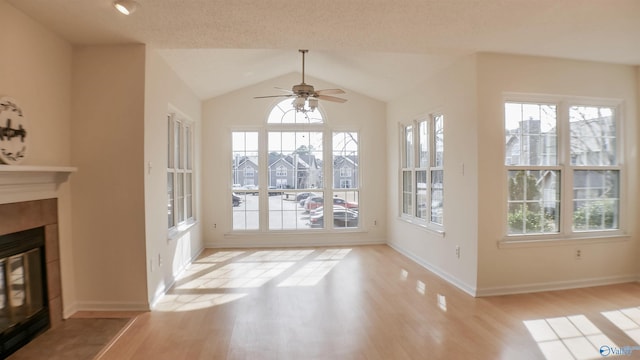 unfurnished sunroom featuring ceiling fan, plenty of natural light, and vaulted ceiling