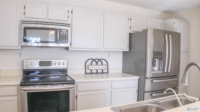 kitchen with white cabinetry, stainless steel appliances, and sink