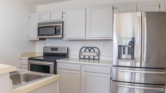 kitchen with sink, white cabinets, and appliances with stainless steel finishes