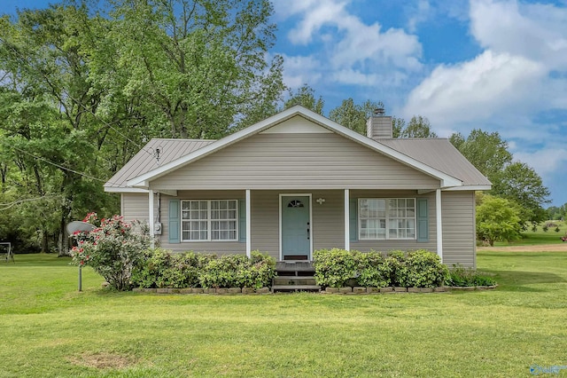 view of front of house with a porch, a front yard, and metal roof