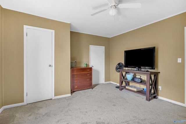 interior space featuring crown molding, baseboards, and ceiling fan
