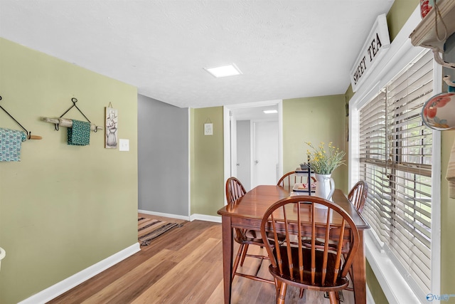 dining area with baseboards and light wood-style floors