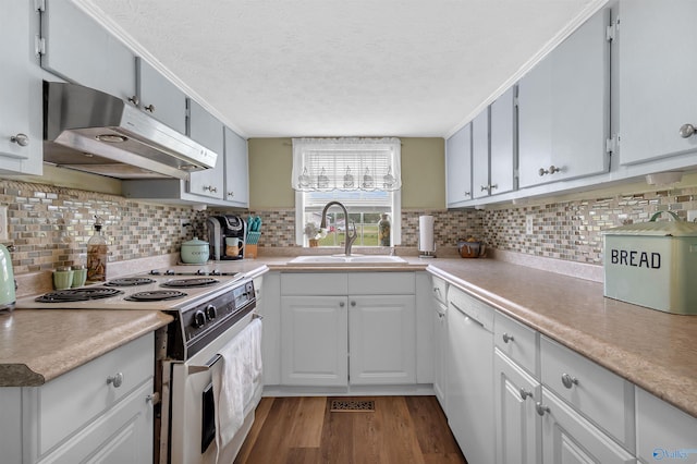 kitchen featuring wood finished floors, a sink, white appliances, light countertops, and under cabinet range hood