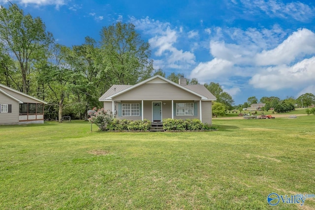view of front of house featuring a chimney, a front lawn, and covered porch
