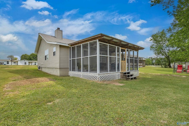 back of property featuring a sunroom and a lawn
