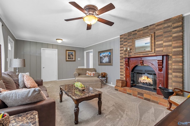carpeted living room featuring a ceiling fan, a glass covered fireplace, and ornamental molding