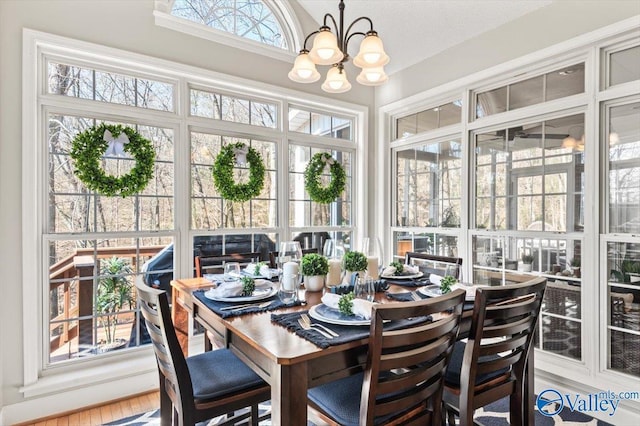 sunroom / solarium featuring an inviting chandelier and lofted ceiling