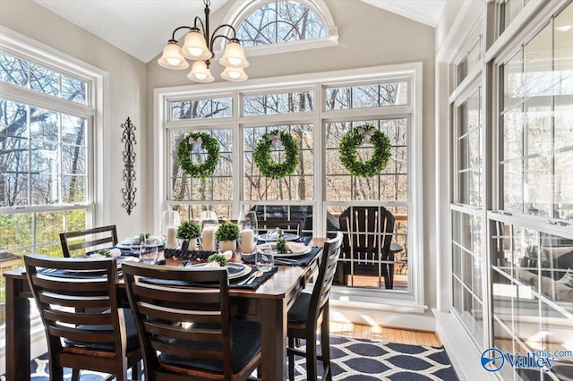 sunroom / solarium featuring vaulted ceiling and a chandelier