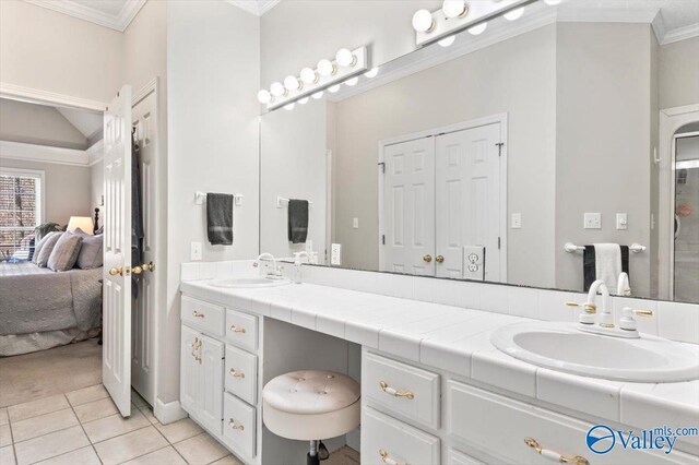 bathroom with double vanity, ornamental molding, ensuite bathroom, and a sink