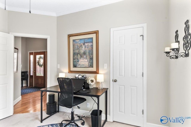 office space featuring baseboards, light wood-style flooring, and crown molding