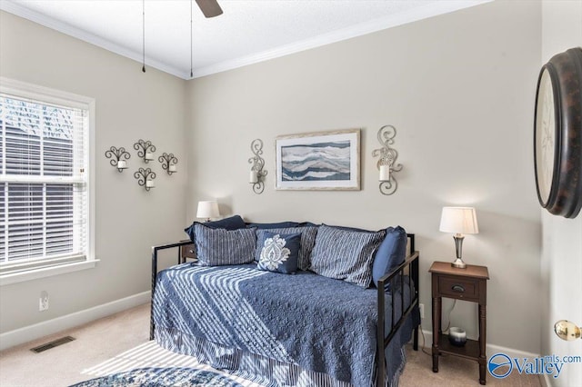 carpeted bedroom featuring visible vents, ceiling fan, crown molding, and baseboards