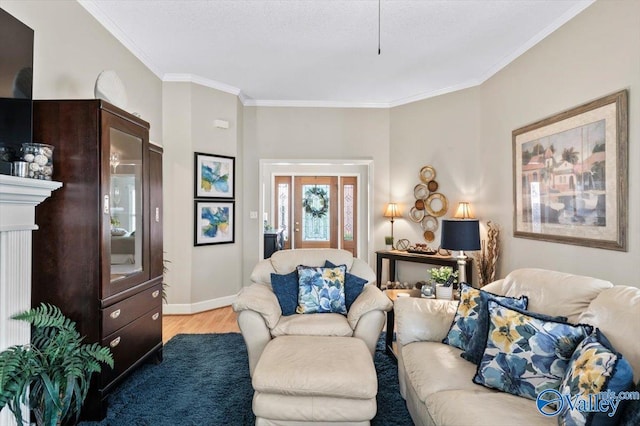 living area with baseboards, light wood-style floors, and crown molding