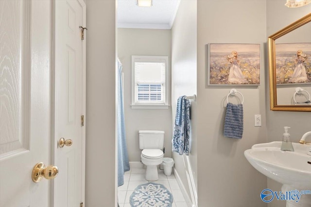 full bathroom featuring tile patterned flooring, curtained shower, toilet, ornamental molding, and a sink