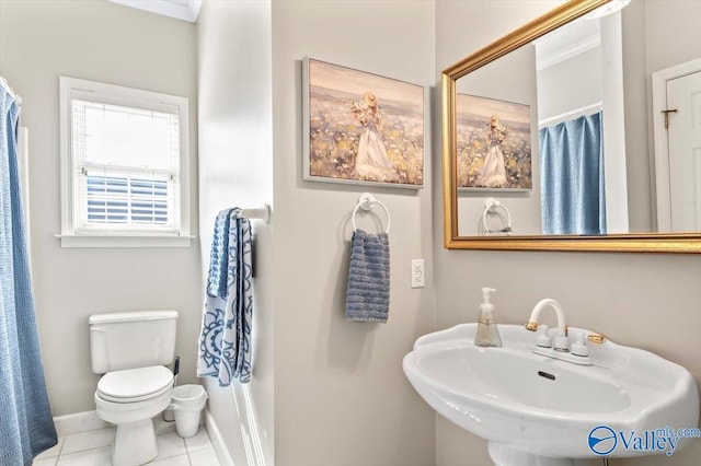 full bath with tile patterned floors, toilet, a sink, curtained shower, and baseboards