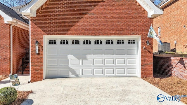 garage featuring cooling unit and concrete driveway