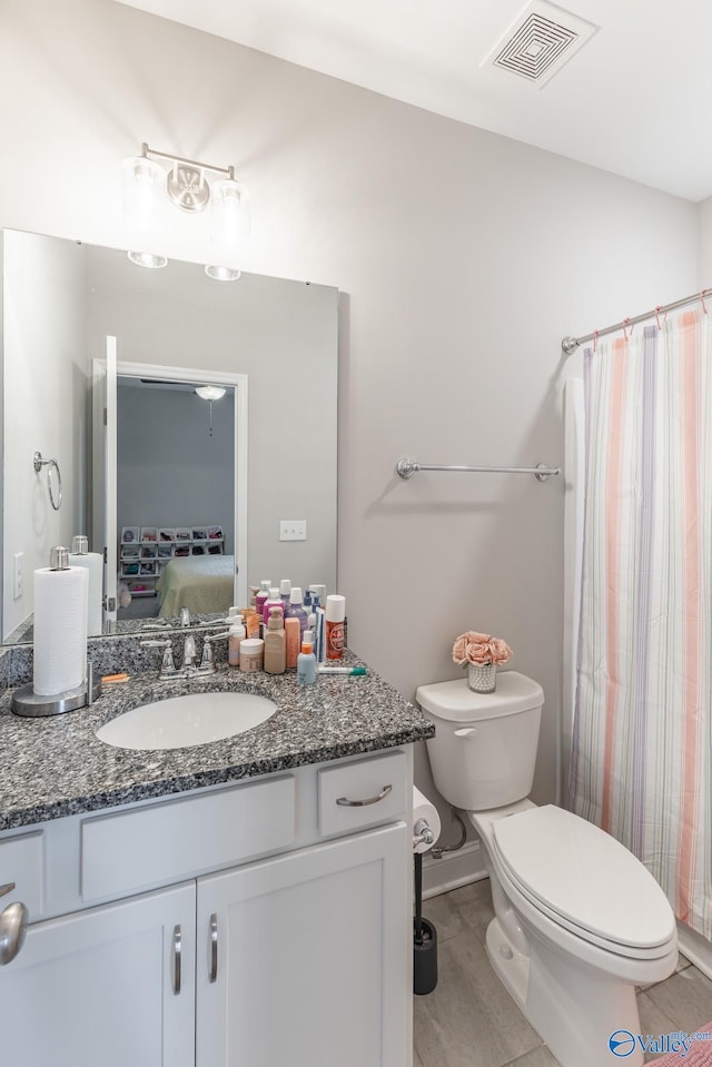 bathroom featuring tile patterned floors, vanity, and toilet