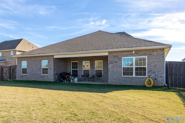 rear view of property featuring a lawn and a patio