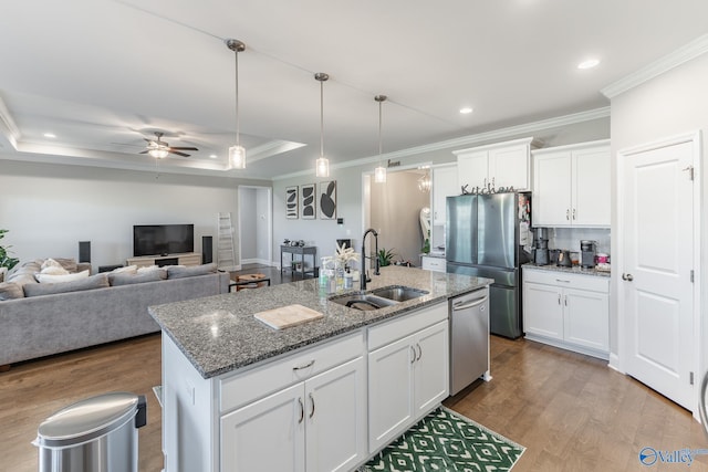 kitchen featuring an island with sink, white cabinets, and stainless steel appliances