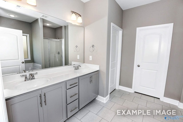 bathroom featuring tile patterned floors, vanity, and a shower with shower door