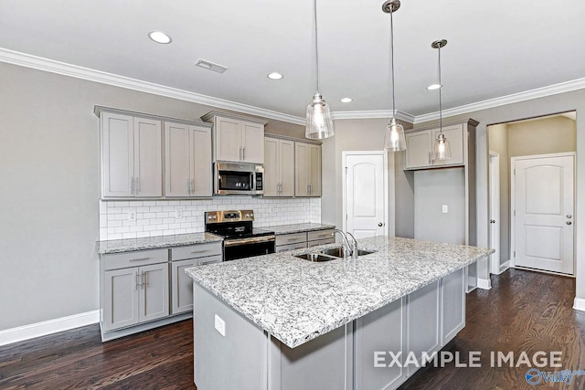 kitchen with sink, tasteful backsplash, light stone counters, pendant lighting, and appliances with stainless steel finishes