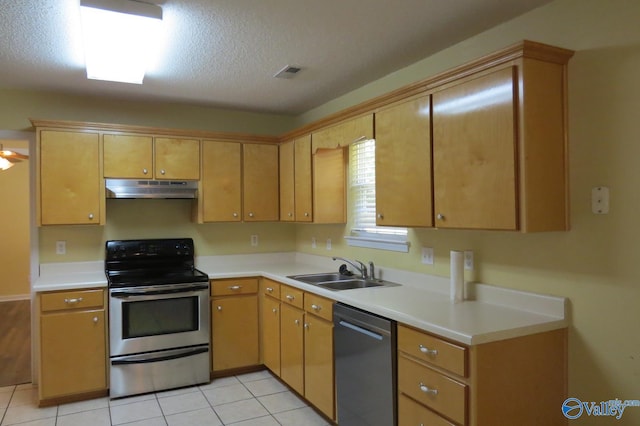 kitchen featuring light tile patterned floors, a textured ceiling, appliances with stainless steel finishes, and sink