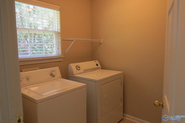 clothes washing area featuring washing machine and clothes dryer and a healthy amount of sunlight