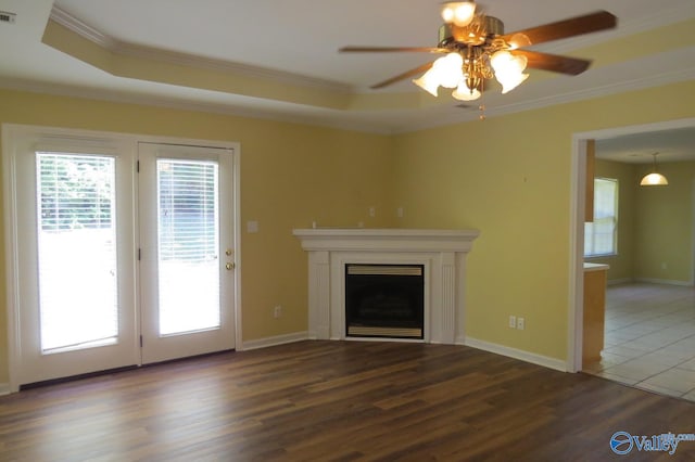 unfurnished living room featuring ceiling fan, ornamental molding, and dark wood-type flooring