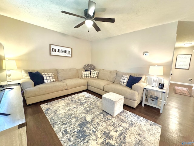 living room with a textured ceiling, ceiling fan, and dark hardwood / wood-style floors